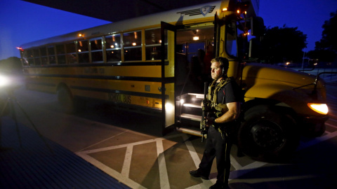 Un agente cerca de un autobús escolar. REUTERS/Mike Stone