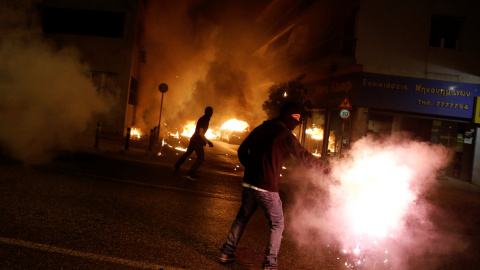 Manifestantes enmascarados arrojan cócteles molotov a los policías antidisturbios al finalizar la marcha antifascista en recuerdo del rapero izquierdista Pavlos Fyssas, asesinado por neonazi de Amanecer Dorado. REUTERS/Alkis Konstantinidis