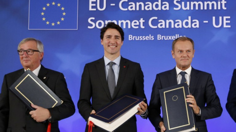 El presidente de la Comisión Europea, Jean Claude Juncker, el primer ministro de Canadá, Justin Trudeau, y el presidente del Consejo Europeo, Donald Tusk, tras la firma del CETA en Bruselas, en octubre de 2017. AFP/François Lenoir