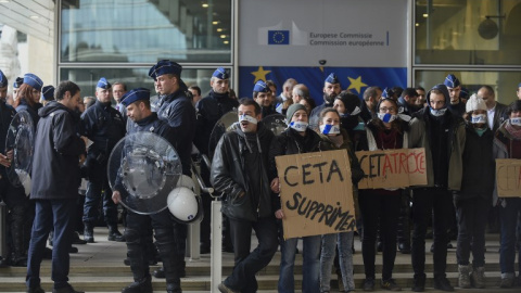 Policías belgas vigilan a los manifestantes concentrados frente al edificio de la Comisión Europea, durante la cumbre UE_canadá de octubre de 2016 en la que se firmó el CETA. AFP/jOHN tHYS