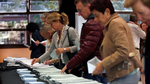 Varios ciudadanos escogen sus papeletas electorales en el Centre Cívic La Sedeta de Barcelona, uno de los 23.194 colegios electorales repartidos en toda España para las elecciones europeas, municipales y autonómicas, unos comicios en los qu