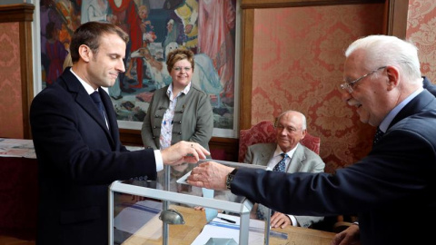 El presidente francés Emmanuel Macron (L) emite su voto en una mesa electoral en Le Touquet. EFE