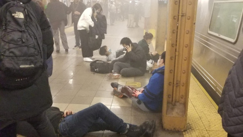 Personas heridas sentadas y tumbadas en el andén con manchas de sangre de la estación de metro de la calle 36 de Brooklyn, donde un hombre ha provocado un tiroteo este 12 de abril de 2022.