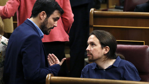 El diputado de IU-Unidad Popular, Alberto Garzón, conversa con el líder de Podemos, Pablo Iglesias, durante la sesión constitutiva del Congreso.-REUTERS