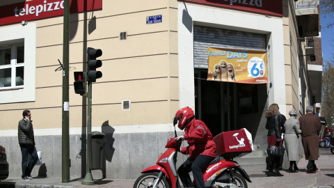 Un repartidor de Telepizza, con su moto, en un establecimiento de Madrid. REUTERS