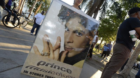 Una fan del fallecido músico estadounidense Prince sostiene un cartel con su imagen. EFE/MIKE NELSON