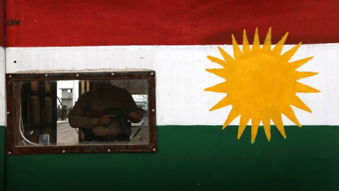 Un 'peshmerga' hace guardia en un control con la bandera kurda en la ciudad de Khazir. - AFP