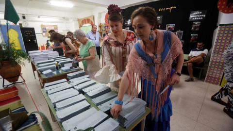 26/05/2019.- Dos mujeres vestidas de flamenca eligen sus papeletas en un colegio de Córdoba donde se está celebrado la Feria de Nuestra Señora de la Salud, hoy 26 de mayo en el que un total de 6,64 millones de electores andaluces podrán eje