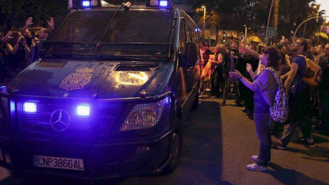 Efectivos de la la Policia Nacional abandonan las inmediaciones de la sede de la CUP en Barcelona ante los aplausos de los centenares de simpatizantes que se han concentrado desde este mediodía. | EFE