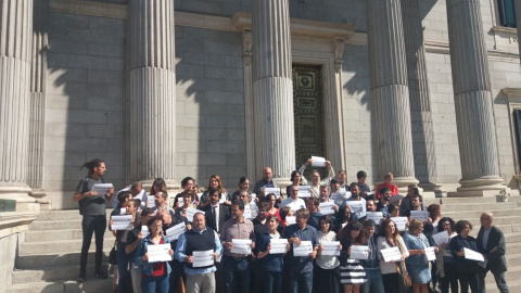 Los diputados portan carteles con el lema "Detencions no, Democràcia sí" a las puertas del Congreso.