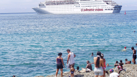 Ciudadanos cubanos contemplan un crucero desde la costa de la isla.