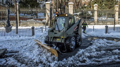 Efectivos de la Unidad Militar de Emergencias UME, despejan de nieve el entorno de la Plaza de Cibeles en Madrid, este domingo. A partir de esta madrugada se espera la llegada de una ola de frío, con un acusado descenso de las temperaturas 