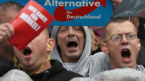 Simpatizantes de Alternativa para Alemania (AfD) gritan durante un acto de campaña de la canciller alemana Angela Merkel el 6 de septiembre del 2017. REUTERS/ Reinhard Krause