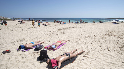 16/04/2022 Varias personas disfrutan de una jornada soleada en la playa de Punta Prima, Menorca, este Sábado Santo