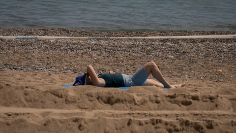 26/04/2023. Una mujer toma el sol en la playa de la Barceloneta, a 25 de abril de 2023, en Barcelona.