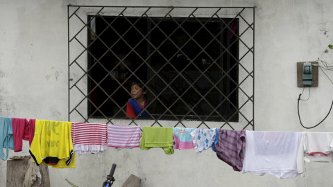 Un niño mira a través de una ventana en su casa dañada en Pedernales. REUTERS/Henry Romero