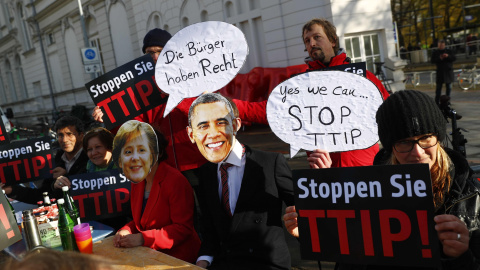 Manifestantes con caretas de Angela Merkel y de Barack Obama protesan en Hannover contra el TTIP. REUTERS/Kai Pfaffenbach