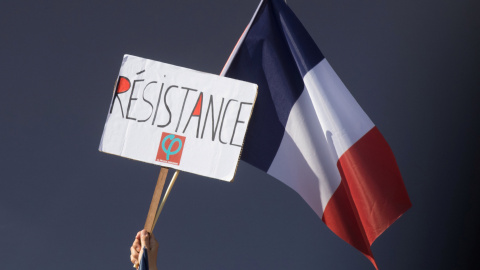 Un manifestante tiene una bandera francesa y un logo de la Francia Insumisa que dice: "Resistencia". REUTERS / Philippe Wojazer