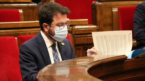 El vicepresident amb funcions de president, Pere Aragonès, durant la sessió de la Diputació Permanent del Parlament d'aquest dimecres revisant documentació al seu escó.