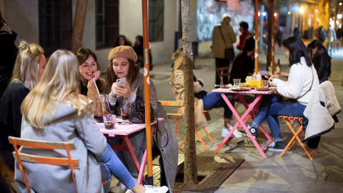 Varias personas conversan en la terraza de un bar de Barcelona, este lunes en el que se ha iniciado la fase 1 de la desescalada en Cataluña con la reapertura, limitada en horario y aforo, de bares, restaurantes, deporte y cultura.