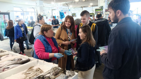 28/4/23 Verónica Hermida, segunda por la izquierda, y María de la O Fernández, concejala y candidata a la Alcaldía de Vilagarcía por Podemos-Marea da Vila, departiendo con una pescantina durante una visita a un mercado.