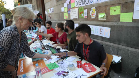 Estudiantes de la Universitat Central en las mesas informativas que han habilitado para orientar a la población sobre el referéndum. EFE/Toni Albir