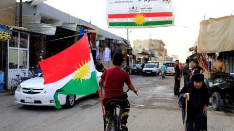 Un niño en bicicleta con la bandera del Kurdistán en una localidad de Irak. REUTERS/Thaier Al-Sudani