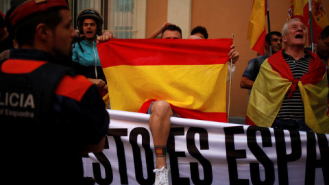 Manifestantes sostienen banderas españolas durante una reunión en apoyo a los guardias civiles españoles fuera de sus cuarteles en Barcelona el pasado ​​21 de septiembre / REUTERS