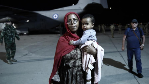 27/4/23 Una refugiada sudanesa con su hijo en el aeropuerto de Attica, en Atenas, el pasado jueves.