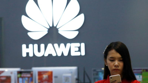 21/05/2019.- Una empleada revisa un teléfono Huawei en una tienda de la marca en Bangkok (Tailandia), este martes. Huawei restó este martes importancia a que las restricciones estadounidenses vayan a afectar a sus productos o al despliegue 