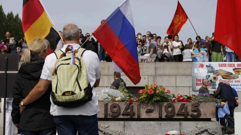 A couple holds a German and a Russian flag during celebrations to mark Victory Day, at the Soviet War Memorial in Treptower Park in Berlin, Germany, May 9, 2015. REUTERS/Fabrizio Bensch