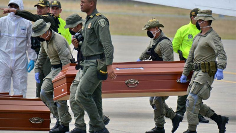 Personal de la Policía ayuda hoy, viernes 22 de junio de 2018, en Cali (Colombia), a cargar los ataúdes con los cuatro cuerpos hallados por las autoridades colombianas en una zona selvática. (ERNESTO GUZMÁN Jr. | EFE)