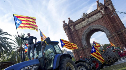 Varios de los agricultores de la comarca de Maresme, de la provincia de Barcelona, que han viajado por carretera hasta la capital y han aparcado una treintena de tractores bajo el Arc del Triomf para expresar su apoyo al presidente de la Ge