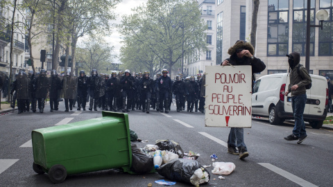 Un manifestante muestra una pancarta en la que se lee "El poder para el pueblo soberano" durante una protesta contra la reforma laboral en París (Francia). EFE/Jeremy Lempin