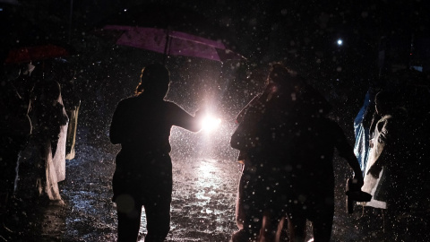 27/04/2022 Gente espera bajo la lluvia noticias de sus familiares detenidos durante el estado de emergencia, en los alrededores de la prisión de Izalco