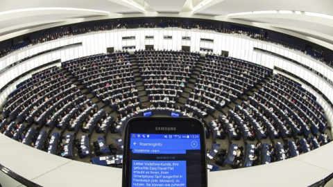 Una persona muestra un SMS con información de "roaming" en su teléfono móvil durante el pleno del Parlamento Europeo en Estrasburgo (Francia) hoy, 27 de octubre de 2015. Los europarlamentarios votan la abolición de los recargos por el uso d