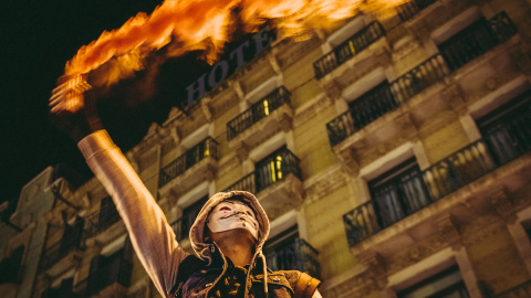 Un manifestante enciende una bengala durante una protesta por las restricciones del covid, a 11 de diciembre de 2021, en Barcelona.