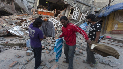 Varias personas recogen lo que queda de sus pertenencias entre los emcombros causados por el terremoto en Katmandú. - EFE