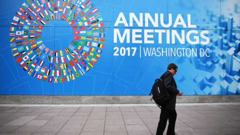 Un caminante pasea junto a la placa que anuncia la reunión anual del FMI. AFP/Jim Watson