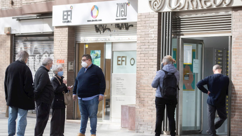 05/02/2021.- Varias personas hacen cola en una oficina de Correos de Barcelona este viernes, último día para admitir peticiones de voto por correo para el 14F. - EFE