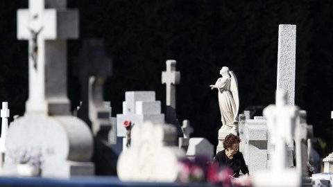 Una mujer visita a sus difuntos en el cementerio de La Almudena de Madrid.- EFE