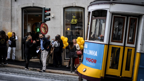 Varios viandantes aguardan el paso del tranvía en Lisboa el 20 de noviembre de 2021.