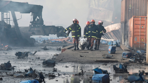 Los bomberos evacúan la zona del incendio en Bangladesh.