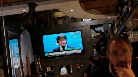 La comparecencia del expresident catalán Carles Puigdemont en Bruselas, en un televisor en un bar cerca de la Plaza de Sant Jaume de Barcelona, el pasado 31 de octubre. REUTERS/Jon Nazca