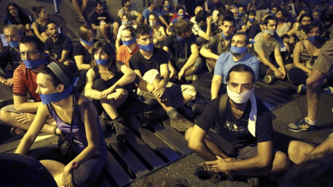 Manifestantes ante el Congreso de los Diputados, en Madrid, han acudido a la llamada de colectivos y organizaciones sociales, englobadas bajo el nombre "gente sin mordaza", que han convocado a una sentada con la boca tapada en protesta por 