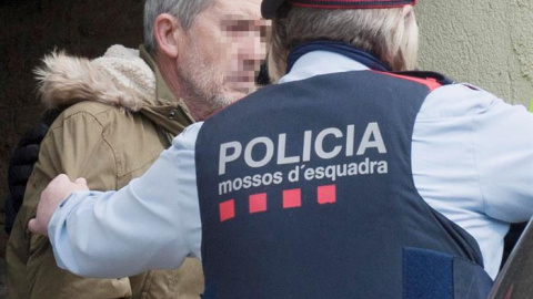 El presunto autor del doble homicidio de Susqueda, Jordi Magentí (i), acompañado de los mosos d'esquadra en el momento de acceder a una casa de Anglès. /EFE