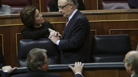 El ministro de Hacienda, Cristóbal Montoro, conversa con la vicepresidenta del Gobierno, Soraya Sáenz de Santamaría, al terminar el pleno del Congreso que ha aprobado la reforma del Concierto Económico con el País Vasco y el nuevo cupo.EFE/