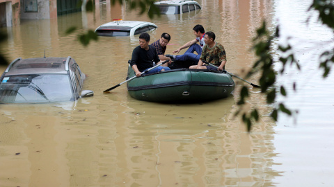 Personas remando en un bote en una zona inundada después de fuertes lluvias en Yongzhou, provincia de Hunan, China. REUTERS / Stringe