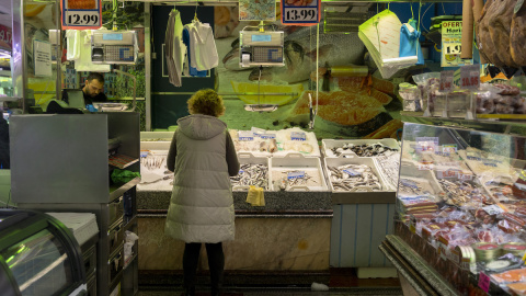 Una mujer compra en una pescadería en un mercado, a 15 de marzo de 2023, en Madrid.