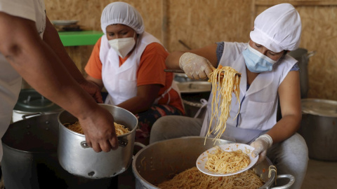 Unas mujeres preparan alimentos en el asentamiento humano de Buena Vista el 2 de febrero de 2021, en el populoso distrito limeño de Villa María del Triunfo, en Lima (Perú).